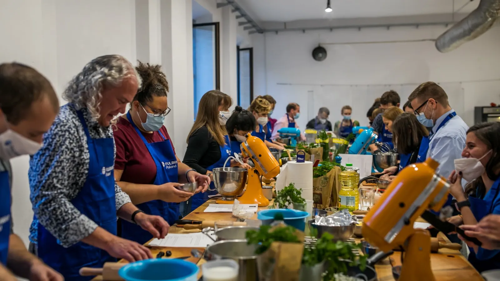 People cooking around a long table