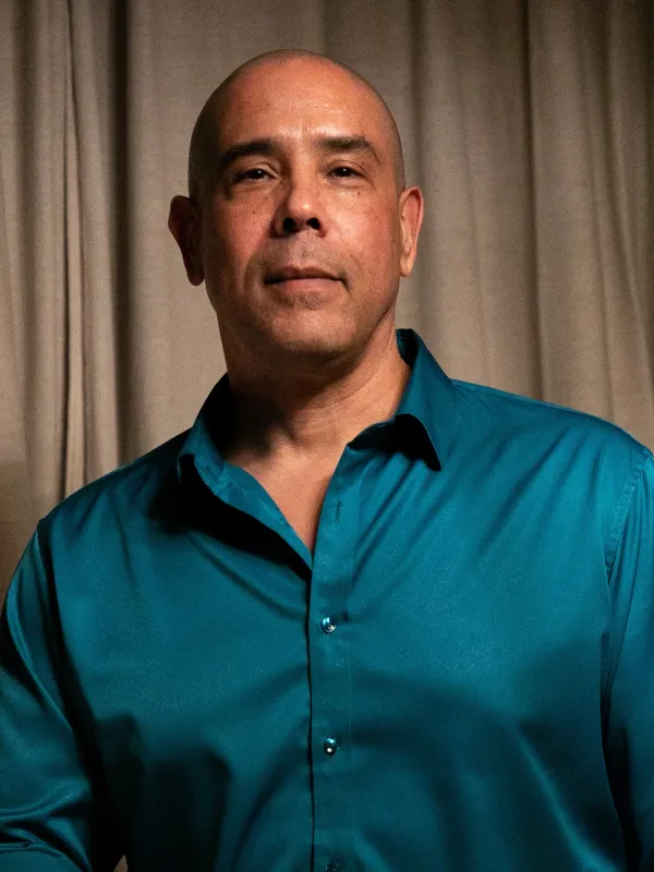 teal shirt against beige backdrop medium range torso