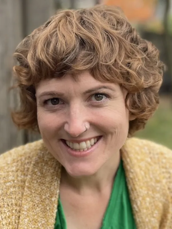 Close up image of smiling white woman with short curly hair
